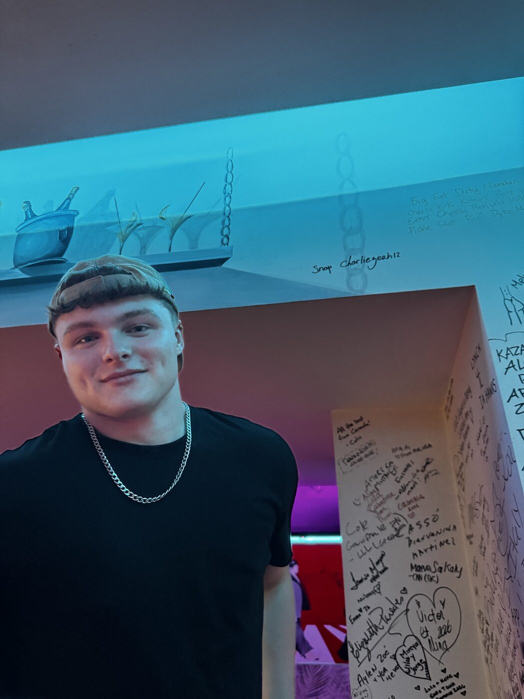 Signatures, hearts and city names written across the pub wall